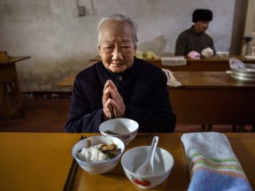 Elderly Chinese resident Chen Minying, 92, prays before lunch in the dining hall of the Ji Xiang Temple and nursing home on March 17, 2016 in Sha County, Fujian province, China.