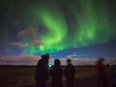 Tourists photograph the Northern Lights near Reykjavik, Iceland.