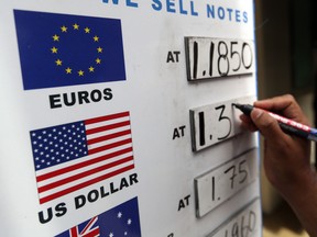 An employee updates exchange rates on a board outside a foreign currency exchange bureau. An Ontario judge has ruled that Bank of Montreal and Toronto-Dominion Bank can be added to a lawsuit alleging a secretive “price-fixing conspiracy” in the foreign exchange market.