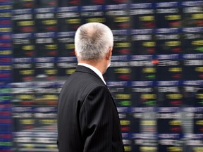 A man walks in front of an electric quotation board displaying the Nikkei key index of the Tokyo Stock Exchange (TSE) in Tokyo on November 16, 2016.  Tokyo stocks opened higher on November 16 as exporters rose on a weaker yen and as energy stocks followed oil prices upward, with investors cheered by encouraging US economic data. / AFP PHOTO / KAZUHIRO NOGIKAZUHIRO NOGI/AFP/Getty Images