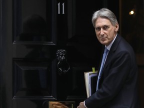 FILE - In this Wednesday, March 21, 2018 file photo, Britain's Chancellor Philip Hammond leaves 11 Downing Street to attend the weekly session of Prime Ministers Questions in Parliament in London. Hammond is expected to outline plans to ensure the nation's financial services industry can thrive after the U.K. leaves the European Union when he delivers a speech to top business executives Thursday, June 21, 2018.