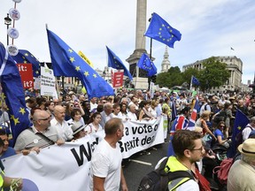 From centre carrying banner, British lawmaker Vince Cable,  Pro-EU campaigners Gina Miller, Tony Robinson and lawmaker Caroline Lucas join crowds taking part in the People's Vote march for a second EU referendum, at Trafalgar Square in central London,  Saturday June 23, 2018. Leading Brexit supporters are talking tough, and opponents are taking to the streets, on the second anniversary of Britain's vote to leave the European Union. Saturday marks two years since a June 23, 2016 referendum resulted in a decision to quit the 28-nation EU.