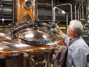 FILE - In this Wednesday Nov. 13, 2013, file photo, Charlie Downs, the artisanal craft distiller at a new Heaven Hill Distilleries, Louisville, Ky., checks gauges on a still that will produce small batches of whiskey. The whiskey industry on Friday celebrated a new state law allowing some bourbon fans to receive home deliveries, shipped straight from their favorite Kentucky distilleries. Bourbon industry leaders and state officials led by Gov. Matt Bevin participated as the first shipments were sent off for delivery.