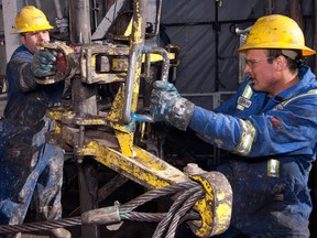 Floorhands operate powered tongs during drilling operations at Baytex Energy Ltd.'s Pembina oil field near Pigeon Lake, Alberta.