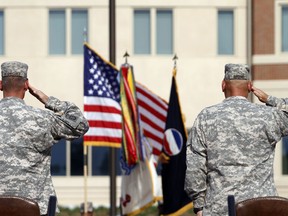 FILE - In this Sept. 12, 2011 file photo, generals salute during an installation ceremony at the U.S Army Forces Command at Fort Bragg, N.C., one the Army's three major command headquarters. The Army is scouting large cities in 2018 to find a home for a fourth command headquarters, one that would be near experts in technology and innovation who can help focus on the Army's future. The site is expected to be announced by the end of June 2018.