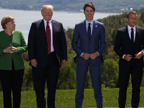 German Chancellor Angela Merkel, President Donald Trump, Canadian Prime Minister Justin Trudeau, and French President Emmanuel Macron gather for the family photo during the G-7 summit, Friday, June 8, 2018, in Charlevoix, Canada.