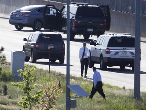 Denver Police Department detectives, foreground, investigate near where a Nissan sedan, top left, being driven by an Uber driver crashed into a retaining wall along Interstate 25 south of downtown Denver early Friday, June 1, 2018. The driver allegedly shot and killed a passenger at 2:45 a.m. after a confrontation broke out between the two while headed southbound on the interstate.