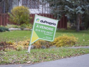 A home for sale sign is shown on the west island of Montreal, Saturday, November 4, 2017.