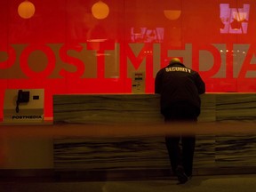 A security guard stands by the front reception desk at Postmedia's Toronto headquarters on Monday, March 12, 2018. Postmedia Network Inc. will close six small town newspapers and cease print publication of four more, as well cut about 10 per cent of its workforce across the newspaper chain.