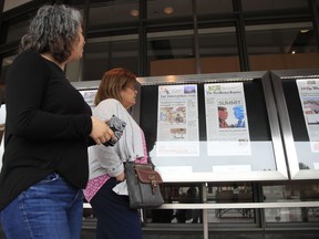 Newseum visitors browse newspaper front pages displayed outside the museum in Washington, Monday, June 11, 2018. There's substantial agreement on what Americans want from the news media and what journalists want to report, according to a pair of studies that also reveal a troubling caveat: a nagging feeling among both the ideal isn't being met.