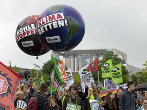 Protestors attend a demonstration demanding the end of burning coal to produce electricity, in Berlin, Germany, Sunday, June 24, 2018. The words on the balloons read: 'Stop Coal' and ' Save Climate'.