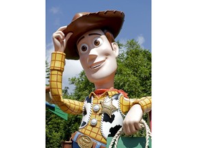 In this Saturday, June 23, 2018 photo, a statue of the character Sheriff Woody greets visitors at the entrance Toy Story Land in Disney's Hollywood Studios at Walt Disney World in Lake Buena Vista, Fla.