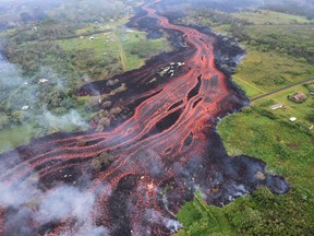 FILE - In this May 19, 2018, file photo released by the U.S. Geological Survey, lava flows from fissures near Pahoa, Hawaii. Technically speaking, Kilauea has been continuously erupting since 1983. But the combination of earthquakes shaking the ground, steam-driven explosions at the top, and lava flowing into a new area some 12 miles (20 kilometers) from the summit represents a departure from its behavior in recent decades. (U.S. Geological Survey via AP, File)