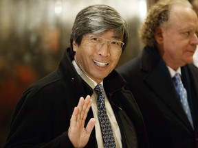 FILE - In this Jan. 10, 2017, file photo, pharmaceuticals billionaire Dr. Patrick Soon-Shiong waves as he arrives in the lobby of Trump Tower in New York for a meeting with President-elect Donald Trump. The Los Angeles Times reports that biotech billionaire Dr. Soon-Shiong officially takes control of the storied newspaper and the San Diego Union-Tribune on Monday, June 18, 2018. Soon-Shiong is spending $500 million for the two news organizations, Spanish-language Hoy and some community newspapers from Chicago-based Tronc. The Times once had more than 1,200 journalists and more than 25 foreign bureaus. Now it employs about 400 journalists.