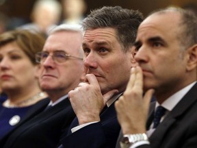 FILE - In this London, Friday, Feb. 24, 2017 file photo, Keir Starmer, second right, of the Labour party listens to Leader of the opposition Labour Party Jeremy Corbyn's speech laying out the plan for the party following the Brexit vote in June 2016. Keir Starmer, the Brexit spokesman for Britain's main opposition party said Wednesday June 6, 2018, that his colleagues are divided over the issue, as British and European businesses sound increasingly urgent warnings about the economic damage the U.K.'s exit from the EU could cause.