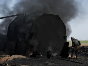 FILE - In this April 6, 2018 file photo, a former farmer works at a primitive refinery as he makes crude oil into diesel and other products, in Rmeilan, Hassakeh province, Syria. The oil ministers of the OPEC cartel are arriving in Vienna to discuss later this week whether to increase production of crude oil and help ease the price of global energy. The officials were gathering Tuesday, June 19 ahead of the official meeting Friday, when they will also confer with the representative of Russia, a non-OPEC member that has cooperated with the cartel to limit production since late 2016.