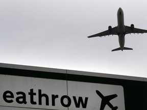 FILE - In this file photo dated Tuesday, June 5, 2018, a plane takes off over a road sign near Heathrow Airport in London.  British lawmakers are set to vote Monday June 25, 2018, on whether to expand Europe's biggest airport, Heathrow.