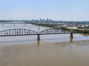 In this photo made Wednesday, June 27, 2018, the Merchants Bridge is seen in the foreground as it crosses the Mississippi River as the St. Louis skyline is seen in the distance. The 127-year-old railroad bridge is in danger of being shut down if it is not replaced soon, but officials are struggling with how to pay for a planned repair and the 12,500 tons of steel the project would require after tariffs were recently enacted.