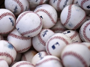 FILE - In this Feb. 22, 2015 file photo, a basket of Rawlings baseballs sits on a practice field as Pittsburgh Pirates catchers take batting practice during a baseball spring training workout in Bradenton, Fla.  Newell Brands is selling iconic sporting goods company Rawlings to a private equity fund for about $395 million.  The sale, Tuesday, June 5, 2018 is part of a broader plan at Newell Brands Inc. to sell some units and focus on key brands. It recently sold its disposable cups and cutlery business for about $2.2 billion.