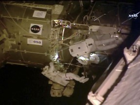 In this photo provided by NASA, from left, astronauts Ricky Arnold and Drew Feustel set up TVs for new crew capsules at the International Space Station, Thursday, June 14, 2018. Their main job involves installing a pair of high-definition TV cameras. The cameras are meant to provide sharp views of commercial crew capsules coming in to dock. Until SpaceX and Boeing start flying astronauts, NASA must rely solely on Russian capsules for getting to and from the 250-mile-high outpost.  (NASA via AP)