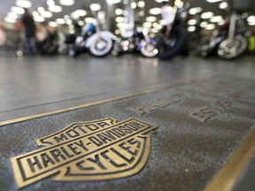 FILE - In this April 26, 2017, file photo, rows of motorcycles are behind a bronze plate with corporate information on the showroom floor at a Harley-Davidson dealership in Glenshaw, Pa. Harley-Davidson, facing rising costs from new tariffs, will begin shifting the production of motorcycles heading for Europe from the U.S. to factories overseas.