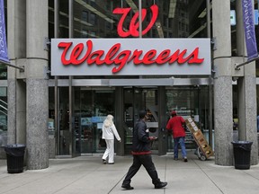 FILE - In this June 4, 2014, file photo, people walk in to a Walgreens retail store in Boston. Walgreens gave investors a better-than-expected third quarter, raised its dividend and detailed a big share buyback Thursday, June 28, 2018. But shares of the nation's largest drugstore chain and its competitors tanked after Amazon.com took another step into their territory by announcing the purchase of PillPack, a relatively new online pharmacy that offers pre-sorted prescription dose packaging and home delivery.
