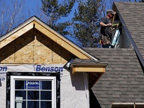 FILE- In this April 23, 2018, file photo, a worker installs vinyl siding on a new home in Auburn, N.H. On Monday, June 18, the National Association of Home Builders/Wells Fargo releases its June index of builder sentiment.
