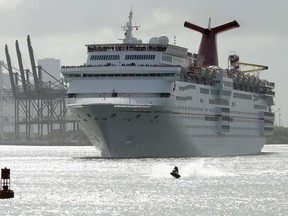 FILE- In this June 20, 2016, file photo, a jet skier passes in front of the Carnival Sensation cruise ship as it leaves PortMiami, in Miami Beach, Fla. Carnival reports financial results on Monday, June 25, 2018.