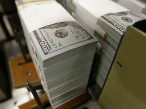 FILE- In this Sept. 24, 2013, file photo, just cut stacks of $100 bills make their way down the line at the Bureau of Engraving and Printing Western Currency Facility in Fort Worth, Texas. On Thursday, June 7, 2018, the Federal Reserve reports on household wealth for the January-March quarter.