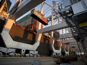 FILE- In this Jan. 30, 2018, file photo, a ship to shore crane loads two shipping containers together onto a vessel at the Georgia Ports Authority's Port of Savannah in Savannah, Ga. China's government renewed its threat Thursday, June 14, to scrap deals with Washington aimed at defusing a sprawling trade dispute as the White House prepared to release a list of Chinese goods targeted for tariff hikes.