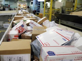 FILE- In this Dec. 14, 2017, file photo, packages travel on a conveyor belt for sorting at the main post office in Omaha, Neb. States will be able to force shoppers to pay sales tax when they make online purchases under a Supreme Court decision Thursday, June 21, 2018, that will leave shoppers with lighter wallets but is a big win for states.