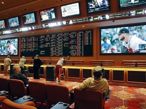 FILE – In this May 14, 2018, file photo, people make bets in the sports book at the South Point hotel and casino in Las Vegas. A day before New Jersey's governor makes his state's first legal wager on a sporting event, sports betting will be the main topic at a major gambling industry conference in Atlantic City. The East Coast Gaming Congress on Wednesday, June 13, will discuss where sports betting stands and what might be next now that New Jersey has won a U.S. Supreme Court case clearing the way for all 50 states to legalize it if they choose.