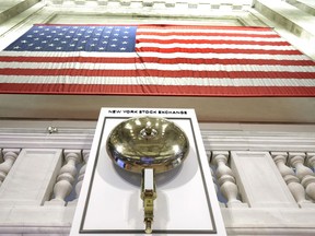 FILE- In this May 17, 2018, file photo an American flag hangs above the bell podium on the floor of the New York Stock Exchange. The U.S. stock market opens at 9:30 a.m. EDT on Monday, June 4.
