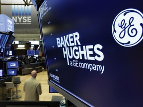 The logo for Baker Hughes appears above a trading post on the floor of the New York Stock Exchange, Tuesday, June 26, 2018. General Electric shed more of its major assets, announcing plans to cast away its health care business and sell its interests in the oil-services company, Baker Hughes.