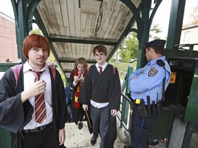 In this Oct. 18, 2014, photo, students from Chestnut Hill College in Philadelphia wear costumes to attend an annual festival based on the Harry Potter fantasy series conceived by British author J.K. Rowling, including Dan Lemoine, second from right, dressed as the title character; Mollie Durkin, second from left, dressed as the character Hermione Granger; and John Spiewak Jr., left, dressed as the character Ron Weasley, as they arrive at the festival in the Chestnut Hill neighborhood of Philadelphia. In 2018, Warner Bros. notified organizers of Harry Potter fan festivals around the U.S. of new guidelines prohibiting any use of names, places or objects from the fantasy series, in an effort to crack down on unauthorized commercial activity at such events.