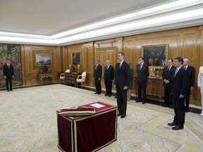 Spain's King Felipe VI waits for Spain's socialist leader Pedro Sanchez, left, to take the oath during the swearing in ceremony in the presence of former Prime Minister Mariano Rajoy, center right, at the Zarzuela Palace on the outskirts of Madrid, Spain, Saturday June 2, 2018. Pedro Sanchez has been sworn in as Spain's Prime Minister by King Felipe VI in a ceremony after coming to power Saturday a day after successfully leading a no-confidence vote to oust conservative Prime Minister Mariano Rajoy. (Fernando Alvarado/Pool Photo via AP)