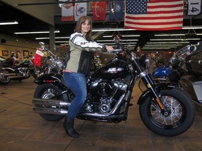 FILE - In this Dec. 12, 2017, file photo, Terri Meehan poses on a 2018 Harley Softail Slim in Milwaukee's House of Harley. Meehan took a riding course at the dealership as part of Harley-Davidson's "Riding Academy," an initiative the company hopes will help bring new customers. Harley-Davidson, the iconic brand that sells its customers an image of freedom and adventure, found itself in an unwanted role this week: poster child for the damage of an international trade war. Harley said it would move production of motorcycles bound for Europe overseas, blaming European Union tariffs it said would add an estimated $2,200 cost to the average bike.