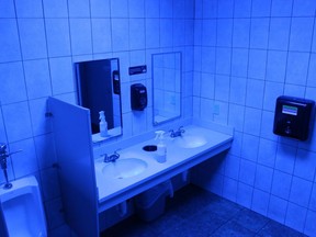 In this June 22, 2018 photo, a public bathroom bathed in blue light is seen at this Turkey Hill convenience store in Wilkes-Barre, Pa. The chain has installed the blue light bulbs in as many as 20 stores in hopes of discouraging drug use by making it harder for people to see their veins.