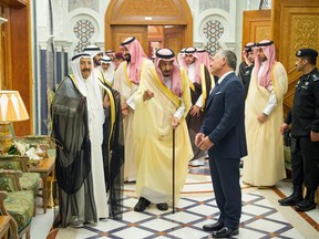 In this photo released by Saudi Press Agency, SPA, Saudi King Salman, center, receives Jordan's King Abdullah II, front right, and Emir of Kuwait, Sheikh Sabah Al Ahmad Al Sabah, left, in Mecca, Saudi Arabia, Monday, June 11, 2018. Three Gulf Arab states pledged $2.5 billion in aid to Jordan on Monday, an effort to stabilize the U.S.-allied kingdom as it faces its worst protests in years over government austerity plans that included tax increases.