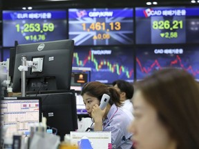 A currency trader talks on phone at the foreign exchange dealing room of the KEB Hana Bank headquarters in Seoul, South Korea, Friday, June 15, 2018. Asian stock markets were mixed Friday after Wall Street largely finished with gains following the European Central Bank's announcement to phase out its bond-buying stimulus. Upbeat U.S. data helped bolstered sentiment.