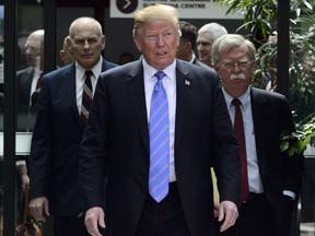 U.S. President Donald Trump leaves the G7 Leaders Summit in La Malbaie, Que., on Saturday, June 9, 2018., with White House Chief of Staff John Kelly, left, and National Security Adviser John Bolton.