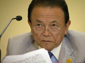 FILE - In this July 24, 2016, file photo, Japan's Finance Minister Taro Aso attends a press conference at the close of the G20 Finance Ministers and Central Bank Governors meeting in Chengdu in Southwestern China's Sichuan province. Aso has taken a one-year salary cut and 20 other officials were penalized for tampering with documents related to a government property sale linked to Prime Minister Shinzo Abe's wife Akie Abe, said Monday, June 4, 2018. The Finance Ministry has acknowledged tampering on hundreds of pages of documents the 2015 land sale to a school where Akie Abe briefly held an honorary position.