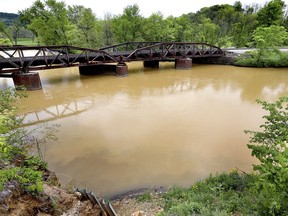 FILE - In this Tuesday, May 22, 2018 file photo, sludge from the Hi-Crush mine in Whitehall, Wis. is seen in the Trempealeau River near Dodge, Wis. Wisconsin officials say early tests have found no harmful chemicals after a spill near a frack sand mine sent millions of gallons of sludge into waterways. A contactor's bulldozer slid into a pond last month, leading to an hours-long rescue at the mine in Whitehall. Rescuers emptied 10 million gallons of water to reach the driver. The spill sent thick sludge into a Trempealeau River tributary, tinting waterways orange as the thick plume traveled downstream and into the Mississippi River.