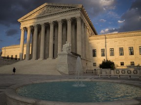 FILE - In this Oct. 10, 2017 file photo, the Supreme Court in Washington is seen at sunset.  In a 5-4 decision Friday, The Supreme Court says police generally need a search warrant if they want to track criminal suspects' movements by collecting information about where they've used their cellphones.