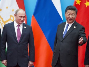 Chinese President Xi Jinping, right, welcomes Russian President Vladimir Putin for talks at the Shanghai Cooperation Organization (SCO) Summit in Qingdao in eastern China's Shandong Province Sunday, June 10, 2018.