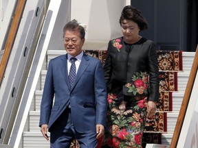 South Korean President Moon Jae-in and his wife Kim Jung-sook, right, step down from the plane upon his arrival in Moscow's Government Vnukovo airport, Russia, Thursday, June 21, 2018. Moon Jae-in will meet Russian President Vladimir Putin on Friday, June 22, 2018.