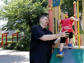 In this Monday, June 4, 2018, photo, Glen Wood, a Canadian who has lived in Japan for 30 years, plays with his son at a Tokyo park. Wood is fighting a courtroom battle in Japan over what he alleges is paternity harassment. He says major brokerage Mitsubishi UFJ Morgan Stanley demoted him and then dismissed him after he took time off to be with his prematurely born newborn son. Although Japan guarantees up to 12 months of paid parental leave, only 3 percent of men exercise that right.