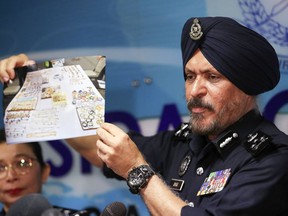 Malaysia's commercial crime investigations chief Amar Singh shows a picture of jewelry during a press conference in Kuala Lumpur, Malaysia, Wednesday, June 27, 2018. Malaysian police say the total value of cash, jewelry and hundreds of watches and handbags seized from properties linked to former Prime Minister Najib Razak in a money-laundering investigation amounted to $273 million.