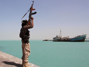 A member of the pro-government forces raises his weapon in the port of the western Yemeni coastal town of Mokha as the Saudi-backed troops advance in a bid to try to drive the Shiite Huthi rebels away from the Red Sea coast.