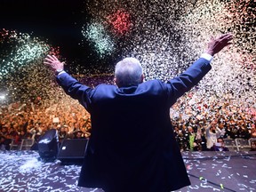 Newly elected Mexico President Andres Manuel Lopez Obrador (C), running for "Juntos haremos historia" party, cheers his supporters at the Zocalo Square after winning general elections, in Mexico City, on July 1, 2018.
